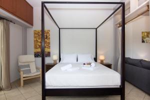 Bostani Seaside House Mani في آغيوس نيكولاوس: غرفة نوم مع سرير بأربعة أعمدة مع ملاءات بيضاء