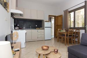 cocina y sala de estar con sofá y mesa en Bostani Seaside House Mani, en Agios Nikolaos