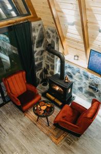 a living room with a wood stove and two chairs at SezBungalov in Ardeşen