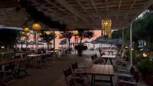 an outdoor patio with tables and chairs and a chandelier at Alex Bar APARTMENTS SARAKINIKO in Parga