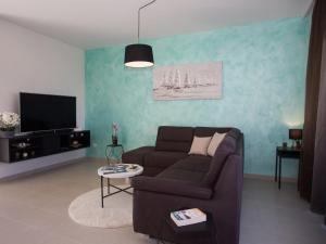 un soggiorno con divano e TV di Villa Orange Tree a Vinišće