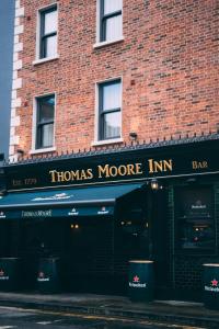 un magasin devant un bâtiment en briques avec une auberge plus thomas dans l'établissement Thomas Moore Inn, à Dublin