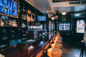 a bar with a row of stools at a bar at Thomas Moore Inn in Dublin