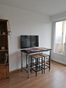 - une table avec des chaises et une télévision dans la chambre dans l'établissement Appartement Circé - Montpellier Nord-Hopitaux-Facultés, à Montpellier
