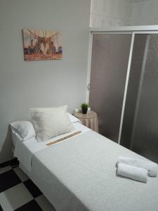 sypialnia z dużym łóżkiem z ręcznikami w obiekcie Pensión Hidalgo 2 w mieście Utrera