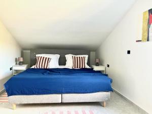 Apartmani Lemona في سيموني: غرفة نوم بسرير ازرق كبير مع وسادتين