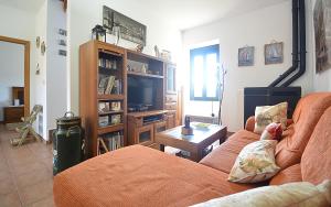 ein Wohnzimmer mit einem Sofa und einem TV in der Unterkunft Casa Rural Manuela in As Mirans