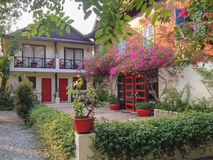 a house with flowers and plants in front of it at The Cockatoo Nature Resort & Spa in Siem Reap