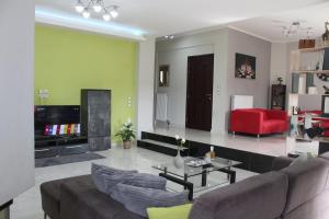uma sala de estar com um sofá e uma cadeira vermelha em Kallia's Modern Apartment em Kissamos
