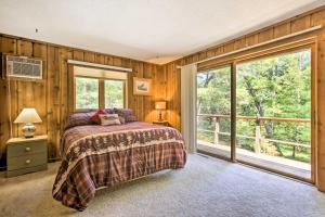 1 dormitorio con paredes de madera, 1 cama y ventana en Tranquil Riverside Home with Wraparound Deck and Views en Baldwin