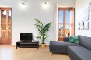 Adarve Flats في فالنسيا: غرفة معيشة مع أريكة وتلفزيون