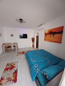 a bedroom with a blue bed and a table at Apartament la dudu in Sulina
