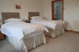 2 camas con sábanas blancas y almohadas en una habitación en Wardicott, en Back