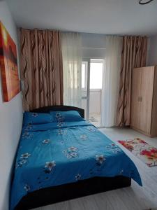 a bedroom with a bed with a blue comforter at Apartament la dudu in Sulina