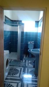 een blauw betegelde badkamer met een toilet en een wastafel bij City View Accomodations Apt 2 in Roseau