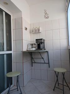 a small kitchen with two stools and a microwave at Apartament la dudu in Sulina