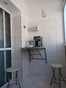 eine kleine Küche mit zwei Hockern und einer Mikrowelle in der Unterkunft Apartament la dudu in Sulina