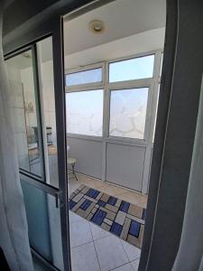 eine offene Tür zu einem Bad mit einem Fenster in der Unterkunft Apartament la dudu in Sulina