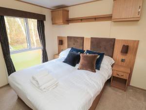 a bedroom with a large white bed with blue pillows at Vista Retreat in Morpeth
