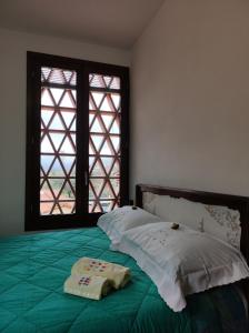 1 dormitorio con cama verde y ventana en L'Appartamentino, en Lucca