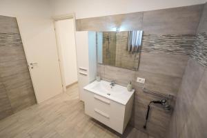 ein Badezimmer mit einem weißen Waschbecken und einem Spiegel in der Unterkunft Il Geranio b&b in Acconia
