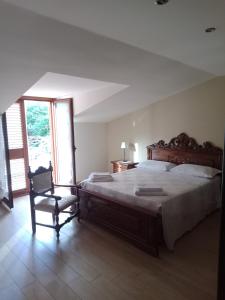 1 dormitorio con 1 cama grande y 1 silla en Alkantara Holiday, en Francavilla di Sicilia