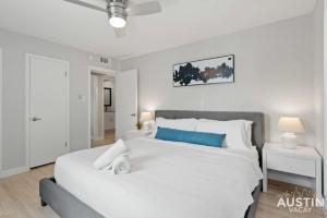 a bedroom with a large white bed with blue accents at All the Essentials For You and Your Pet in Hyde Park in Austin