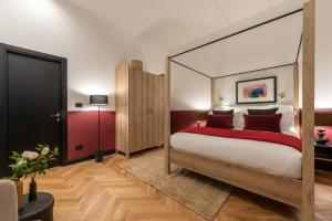 a bedroom with a canopy bed with red pillows at The Couper Castello in Milan