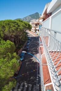 vista sull'alto di una strada con auto parcheggiate sulla strada di Piccolo Hotel Nuova gestione a Cala Gonone