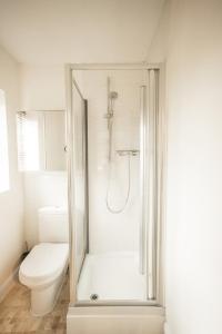 y baño blanco con ducha y aseo. en Upton Grange Townhouse sleeps 10, en Mollington