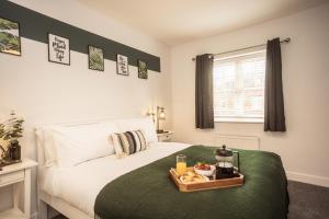 a bedroom with a bed with a tray of food on it at Upton Grange Townhouse sleeps 10 in Mollington