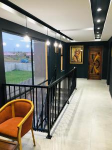 Cette chambre dispose d'un escalier avec une chaise et une fenêtre. dans l'établissement Black Rose Guesthouse, à Soweto