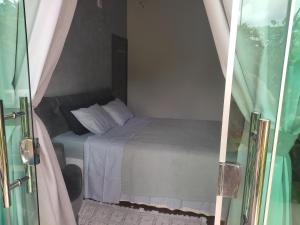 um pequeno quarto com uma cama e uma porta de vidro em Casa do Sossego em Brasília
