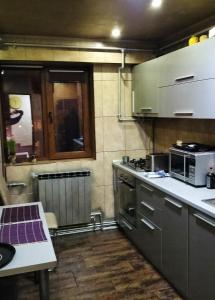 a kitchen with stainless steel appliances and a table at Apartament Luxury in Constanţa