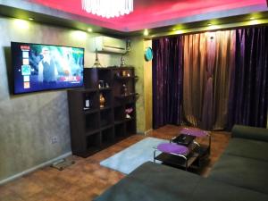 ein Wohnzimmer mit einem Flachbild-TV an der Wand in der Unterkunft Apartament Luxury in Constanţa