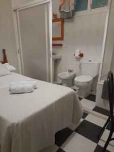 a bathroom with a bed and a toilet at Pensión Hidalgo 2 in Utrera