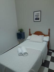 ein Schlafzimmer mit 2 Betten und Handtüchern darauf in der Unterkunft Pensión Hidalgo 2 in Utrera