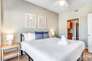 a bedroom with a large white bed with blue pillows at Space for 8 Near Downtown Easy Walk to UT Campus in Austin
