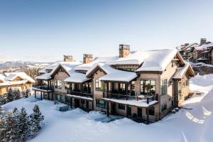a house in the snow with snow covered roofs at Inspiration Point Townhome 8C in Big Sky