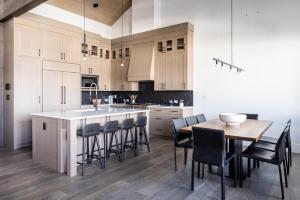 a kitchen with white cabinets and a wooden table and chairs at Inspiration Point Townhome 8C in Big Sky