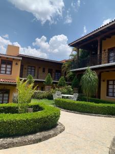 une cour d'un bâtiment avec des buissons et des arbres dans l'établissement Hotel Jardín de Tereza, à Comitán de Domínguez