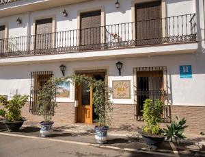 a building with potted plants in front of it at Hostal San Juan in Salobreña