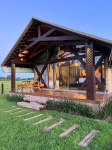 a house with a wooden deck in the grass at Vicença Glamping in Praia Grande