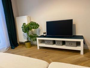 a living room with a tv on a white table at Wileńska home apartment 3 in Warsaw