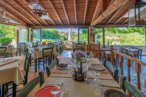 Corfu Sokraki Villas في Sokrákion: مطعم به طاولات وكراسي ومطل على الماء