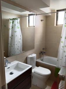 Un baño con inodoro, lavabo y bañera. en ACOGEDOR ÀPARTAMENTO A CUADRAS DE CAVANCHA, en Iquique