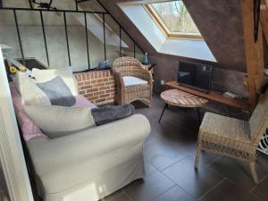salon z kanapą i telewizorem w obiekcie Le Paddock Du Val De Lys w mieście Blessy