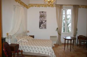 a bedroom with a bed and a table and windows at Grande Maison Mirabelensis - chambres d'hôtes in Mirabel