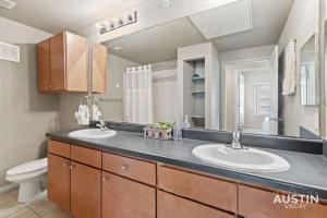 a bathroom with two sinks and a toilet at Perfect Location Near UT and Large Patio With A View in Austin +28 photos
