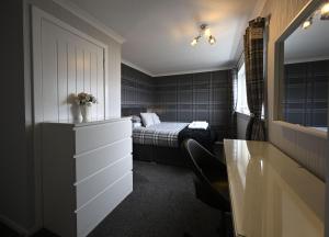een slaapkamer met een bed en een dressoir met een lade bij Sealladh Mairi in Fort William